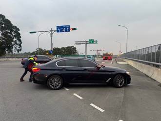 BMW豪车抛锚卡交流道口 寒雨中龙潭暖警推车即刻救援