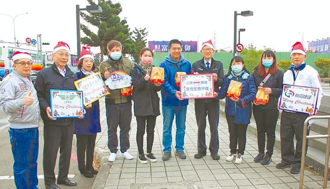 桃园市大坪顶环状线公车今年载客量成长2成，桃园副市长王明鉅（右四）23日特别在耶诞前夕到A7站发早餐给搭公车转乘机捷的旅客，鼓励多搭乘大眾运输，节能减碳。（蔡依珍摄）