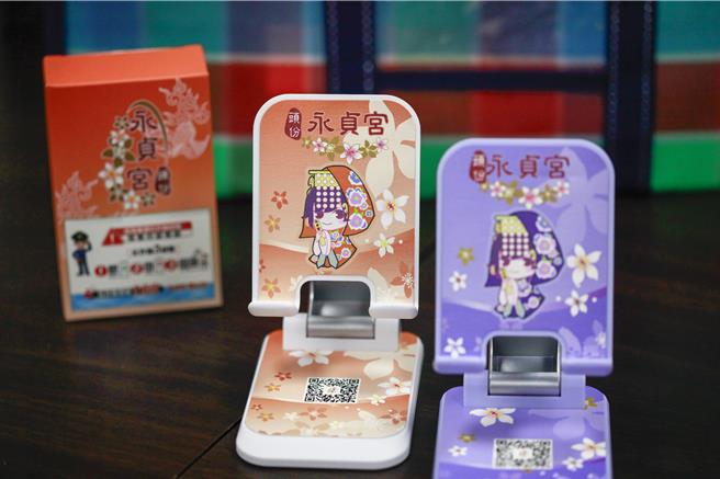 头份永贞宫与头份分局携手打击诈骗，推出一系列防诈小物，如印有QR码的手机架及吊饰，随时提醒民眾提高警觉。（吕丽甄摄）