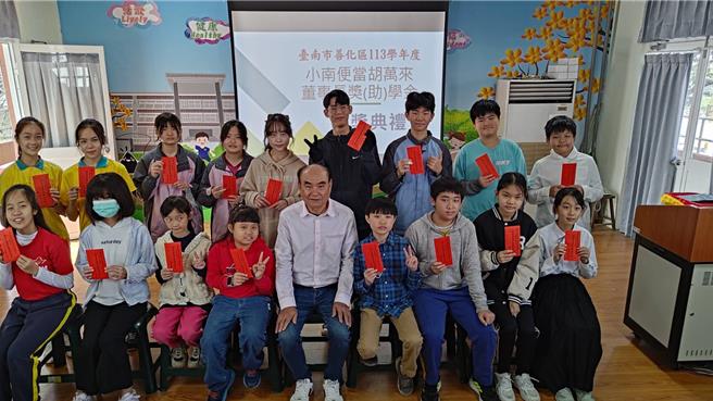 小南便当董事长胡万来（前排右五）25日在善化区茄拔国小颁发奖学金给17名学生。（民眾提供／宝智华台南传真）