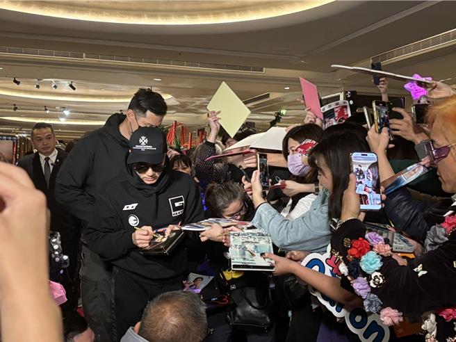 郭富城一抵达饭店就受到粉丝包围，他亲切地停下来签名。（黄雯犀摄）