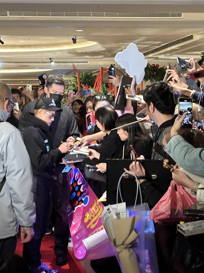 郭富城一抵达饭店就受到粉丝包围，他亲切地停下来签名。（黄雯犀摄）