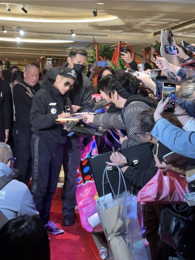 郭富城一抵达饭店就受到粉丝包围，他亲切地停下来签名。（黄雯犀摄）