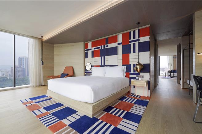 高雄英迪格酒店的「单卧套房／特大床带起居室及用餐区／公园景观」房型。（高雄英迪格酒店提供）