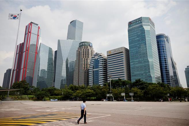 疫情期间一名男性路过首尔商业区附近空无一人的公园（图／路透社）