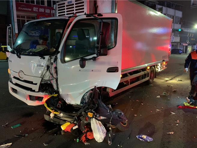 由於撞擊力道過強，機車幾乎是卡在大貨車左前側車輪處，並且嚴重扭曲變形、滿地車殼碎片。（民眾提供／紀爰高雄傳真）