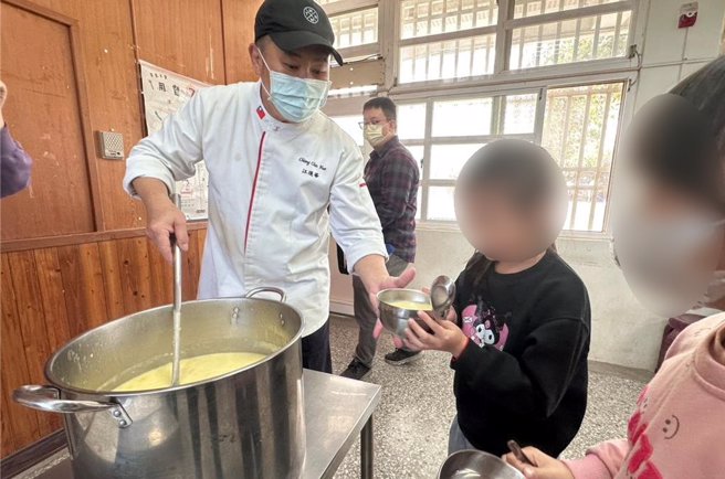 高雄翰品酒店行政主厨「阿华师」江进华（左），26日前往四湖乡南光国小捐赠2万元作为校务发展基金，并煮了1锅拿手的玉米浓汤，让学童暖胃又暖心。（张朝欣摄）
