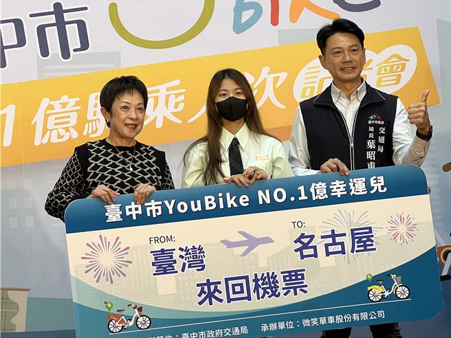 台中市YouBike骑乘数破亿，第1亿名YouBike骑乘者方姓女高中生（中）26日现身市府，由交通局长叶昭甫（右）颁赠台湾、日本名古屋机票。（林欣仪摄）