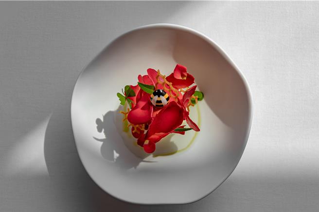 甜点「覆盆子帕芙洛瓦」以蛋白饼为主体，工序繁复，表面以层层迭迭的巧克力花瓣脆片与巧克力小蜜蜂点缀，既香甜又淘气。（北投丽禧温泉酒店提供）