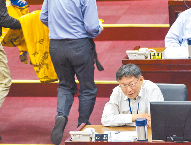 图为2018年时任民进党台北市议员王世坚在质询时送柯文哲龙袍，柯对此露出无奈表情。（示意图／资料照）