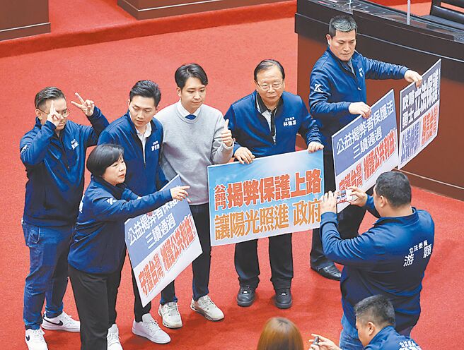 立法院27日院会三读通过「揭弊者保护法」草案，国民党立委拿标语合影。（姚志平摄）