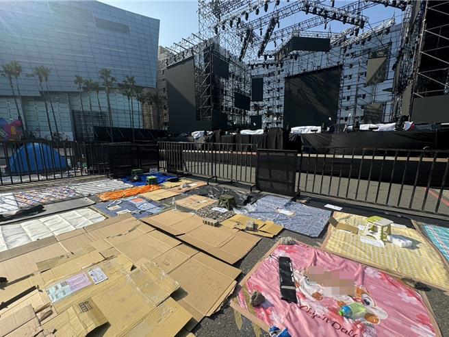 民眾出動野餐墊、紙箱等物卡位，還有人現場搭帳棚輪班等候。（洪靖宜攝）