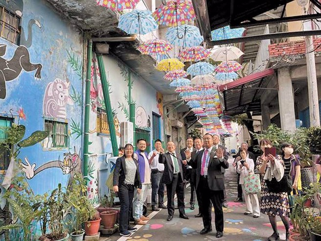 猫巷位于甲仙邮局旁，游客可在伞间透下的天光中与卡通猫咪互动同乐。（林雅惠提供）