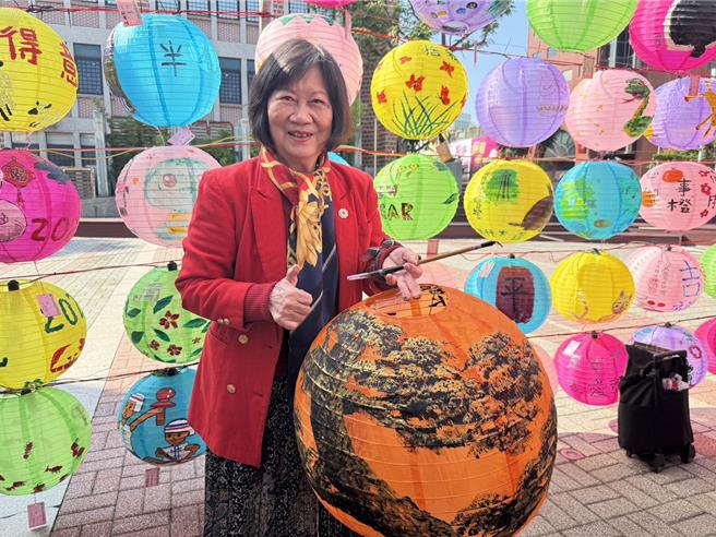 彰化县彰化市公所29日在彰化艺术馆前广场举办「艺术家彩绘灯笼」，其中，书画大师陈美子，退休后才开始研习书画并持续深造，去年以80岁高龄取得大叶大学博士学位，展现「活到老学到老」精神，在现场以松树创作祝福国运长青。（潘虹恩摄）