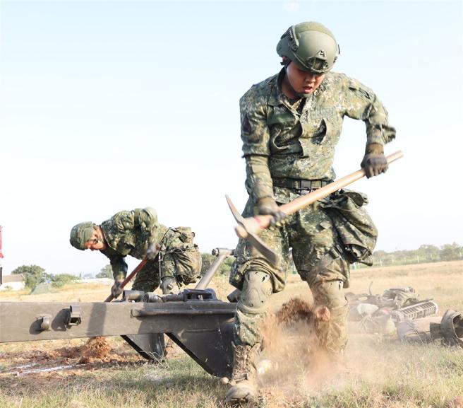  官兵进入炮阵地后，立即确认射向及挖掘驻锄坑等工事，迅速完成火炮架设。（记者傅文琦摄）