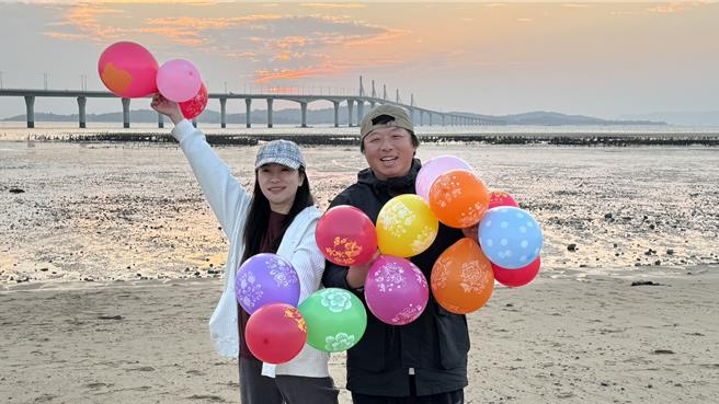 2024年金门的最后一道夕阳于下午5时30分日没，近百名陆客朝圣金门大桥绝美夕阳景色，齐聚于湖下海堤抢拍美景。（于家麒摄）