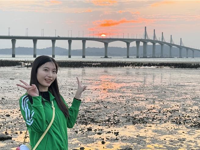 2024年金门的最后一道夕阳于下午5时30分日没，近百名陆客朝圣金门大桥绝美夕阳景色，齐聚于湖下海堤抢拍美景。（于家麒摄）