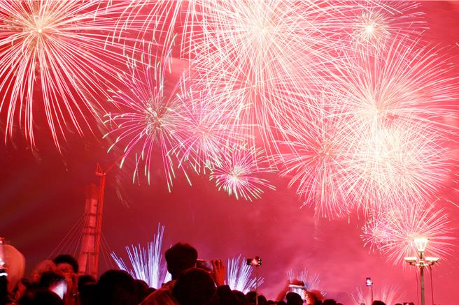 新北市「闪耀新北1314跨河烟火」31日晚间8时25分起在淡水河上空施放长达13分14秒的璀璨烟火秀。（张铠乙摄）