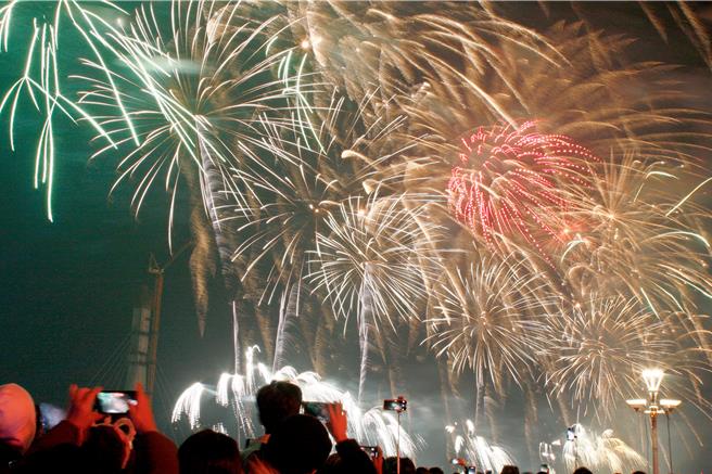 新北市「闪耀新北1314跨河烟火」31日晚间8时25分起在淡水河上空施放长达13分14秒的璀璨烟火秀。（张铠乙摄）