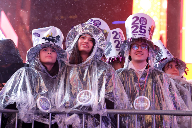 31日民眾穿起雨衣在纽约时报广场上等待跨年倒数。（路透社）