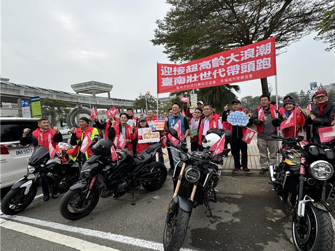 高举「迎接超高龄大浪潮 台南壮世代带头跑」旗帜，壮世代元旦升旗过后展开车队游行。（曹婷婷摄）
