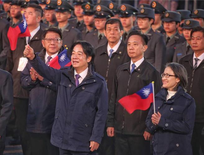 中华民国114年元旦升旗，赖清德总统（左）与副总统萧美琴（右）手持小国旗、唱国歌。（台北市摄影记者联谊会提供）