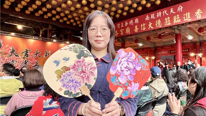 南鲲鯓代天府今（1）日举办「写春联、赠春联」活动，庙方特别聘请师傅以水墨风格绘制600支团扇，民眾掷出一个圣筊即可获得。（张毓翎摄）