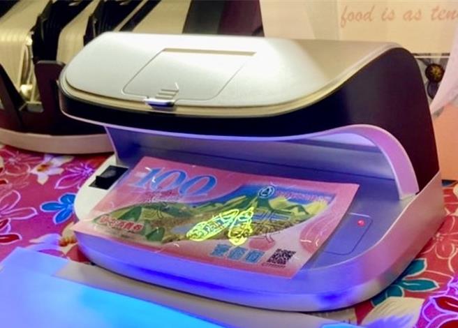 草屯镇公所2日公布消费劵样式，每张面额为100元，正面在紫外光灯下出现一双萤光草鞋。（杨静茹摄）