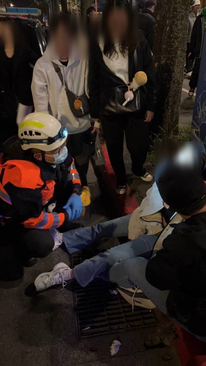 警方發現一名女子因現場擁擠導致呼吸不適，立即啟動緊急救助程式，疏散周圍人群，將該名民眾背離現場，並第一時間通知救護車前來協助送醫。（圖警方提供／簡銘柱翻攝）