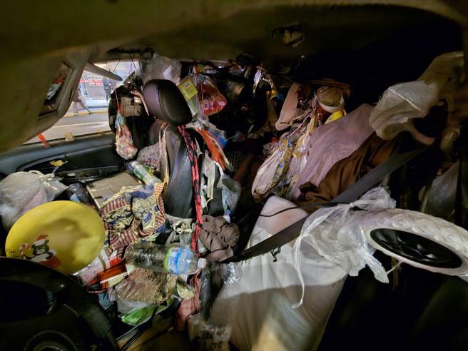 71歲婦人以車為家，車內雜物塞爆景象驚人。（記者游定剛拍攝）