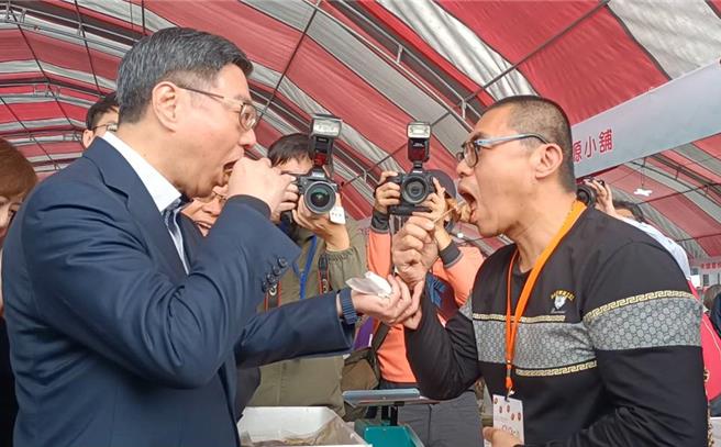 台湾更生保护会4日在台中西屯举行80周年庆，行政院长卓荣泰（左）与更生人小胖（右）同框吃咸猪肉。（陈淑娥摄）