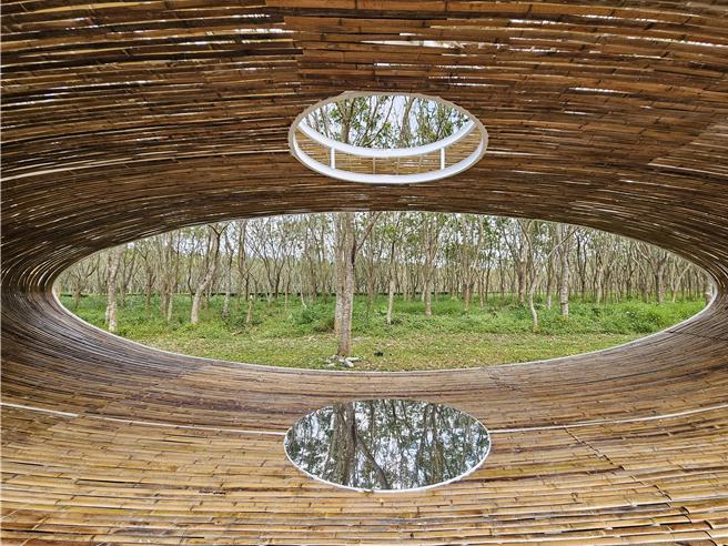 《納》運用300根國產桂竹、刺竹及鋼構創作而成，上方透空，下方圓鏡反映出天空，在森林中與光影交織出詩意場域。（羅琦文攝）