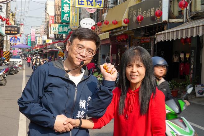 賴瑞隆到林園區市場發送春聯，與市民熱情握手爭取支持。（賴瑞隆辦公室提供／郭良傑高雄傳真）