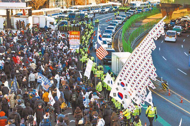 韩国检调3日前往尹锡悦总统官邸执行逮捕令，遭到总统警卫处200多名军警阻拦，经5个半小时对峙后，检调放弃行动无功而返。图为支持尹的群眾在总统官邸附近抗议。（路透）