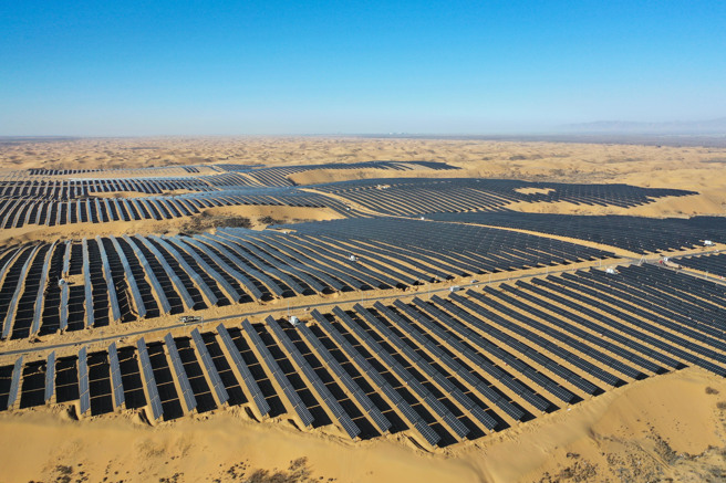  冬日时节，在内蒙古鄂尔多斯市达拉特旗的库布其沙漠呈现一派苍茫雄浑的景象。图为2024年12月25日拍摄的光伏先导工程二期项目区。（图／新华社）