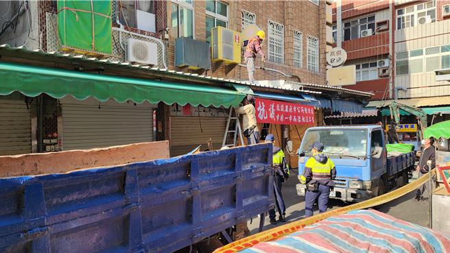 澎湖北辰市场西侧商家违法遮雨遮6日下午开拆，有些商家的抗议红布条仍继续高挂。（许逸民摄）