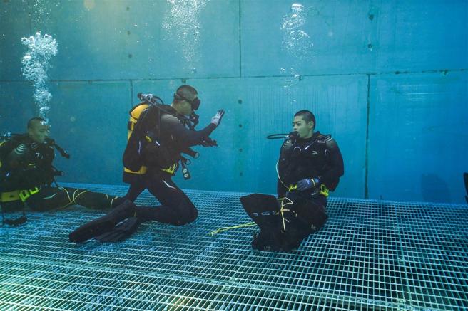 學員演練「夥伴纏繞」課題，救援潛水員熟練地操作工具解除纏繞，並將夥伴帶出水面，完成纏繞救援。（記者謝承宏攝）