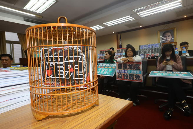 圖為立法院內政委員會去年11月20日排審選罷法修正草案，民進黨立委佔據主席台，並準備標語及道具表達訴求。（資料照／劉宗龍攝）
