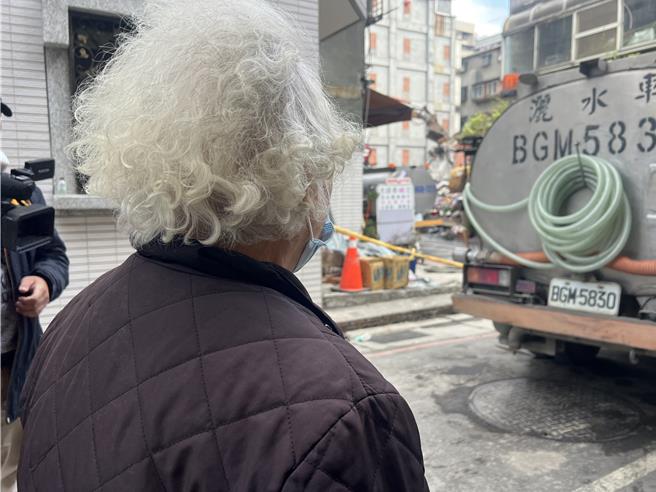 年過7旬的曹奶奶看著正在拆除的工地，心繫一旁嚴重傾斜、丈夫辛苦打拼的「起家厝」。（呂健豪攝）