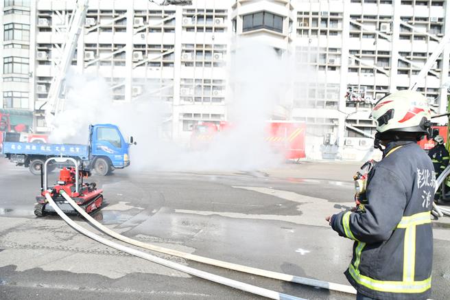彰化县今（7）日举办「彰化县智慧消防．科技救灾」演练，消防人员操作机器人加入救灾演练行列。（叶静美摄）