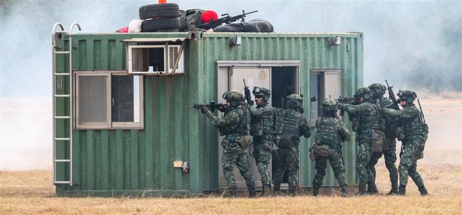  特战分队在机枪火力掩护下进入家屋进行搜索，并成功肃清残敌。（记者谢承宏摄）