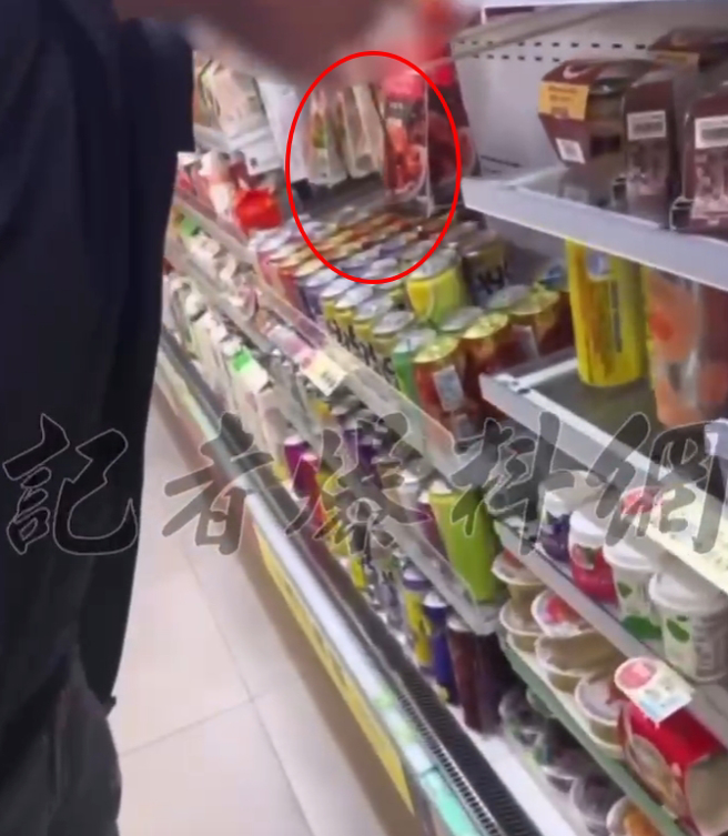 一名穿着黑色外套、紧身牛仔裤的男子站在饮料柜前，突然朝前方的冰柜孔洞吐出深红色的槟榔汁。（翻摄记者爆料网）