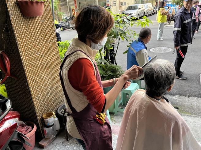 美髮师当场免费帮民眾剪头髮，欢喜迎接新年。（张妍溱摄）