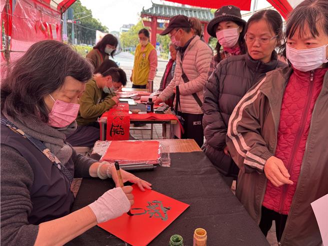 书法老师现场挥毫，民眾可以拿到「刚出炉」免费的春联，又可以近距离感受书法老师挥毫创作的风范。（陈雅惠服务处提供／张妍溱台中传真）