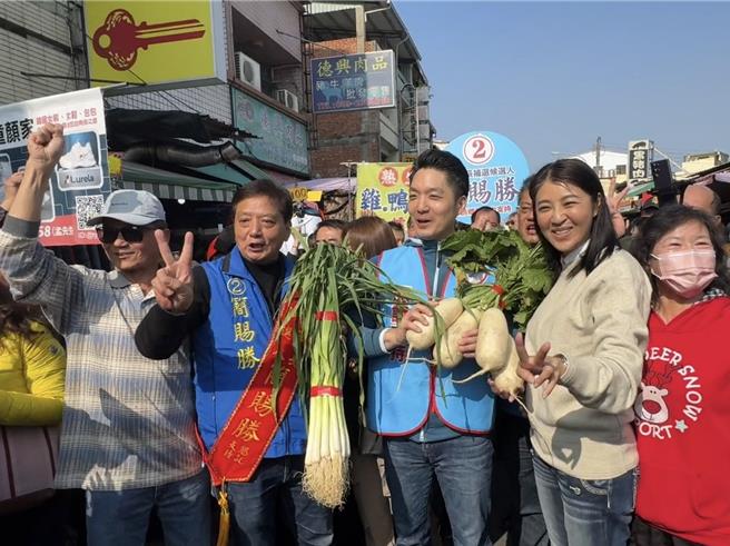 南投縣草屯鎮長補選將於下18日登場，國民黨台北市長蔣萬安、南投縣長許淑華11日上午陪同同黨候選人簡賜勝到菜市場掃街，民眾送上菜頭祝福。（潘虹恩攝）