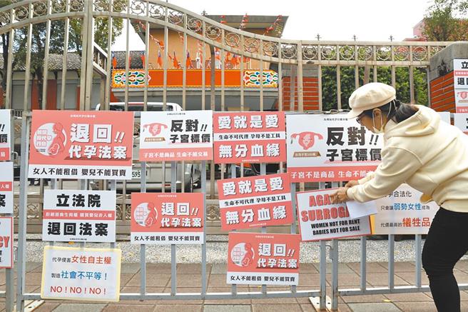 日前有妇女人权团体在立法院门口贴上标语抗议，强调代孕目前并无社会共识，呼吁停止审查与代孕制度相关的法案内容，坚决反对将女性的子宫商品化。（资料照，邓博仁摄）