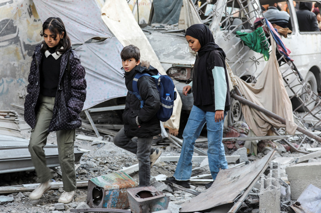 2025年1月9 日，巴勒斯坦人在加薩地帶中部努塞拉特檢查以色列襲擊一所房屋的地點。（路透社）