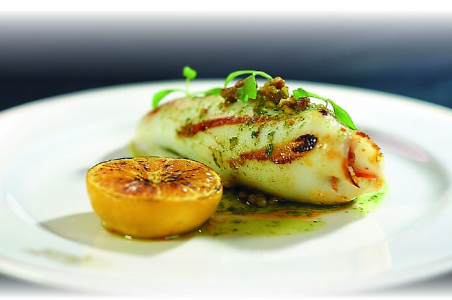 「镶馅透抽佐西班牙腊肠．香料青葱酱汁」是以东北角透抽，灌入由西班牙Chorizo腊肠丁、洋葱、豆眼、麵包丁等配料调制的馅料后香煎，并以用法国依思尼发酵奶油、青酱、辣椒与坚果调制而成的焦化奶油酱提味，搭配炙烧日本砂糖橘呈盘。图／姚舜