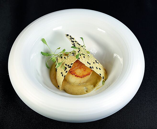 「香煎干贝」底部酱泥是以发酵四季豆、干贝高汤及以白芝麻、迪戎芥末酱、米醋、清酒及奶油制成的芝麻四季豆酱，加上以菊芋、白酒及雪莉醋制成的菊芋泡泡提味，搭配烤菊芋芝麻脆片呈现。图／姚舜