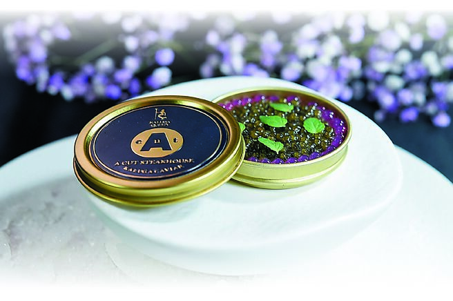 米其林一星「A CUT」牛排馆每季套餐，都会用不同食材搭配演绎的「鱼子酱」，本季是是鰤鱼加上盐昆布、青酸豆碎、柠檬油提升鱼肉的鲜甜味，底下再衬巨峰葡萄果肉，以自然甜味与咸鲜鱼子酱交织美味。图／姚舜